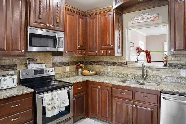 a kitchen with granite countertop a sink stove and cabinets