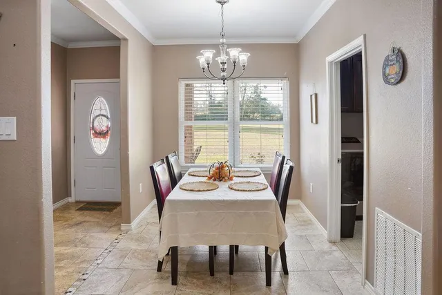 a dining room with furniture a rug and a chandelier