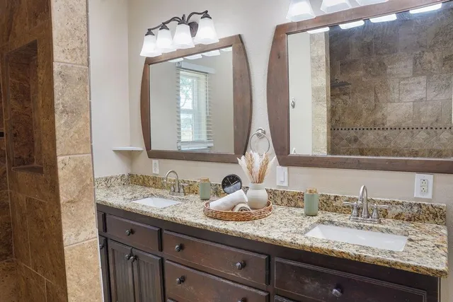 a bathroom with double vanity sinks and a mirror