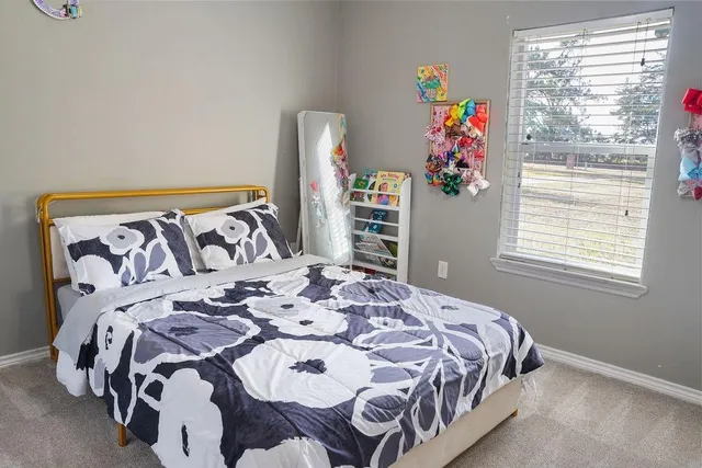 a bed sitting in a bedroom next to a window