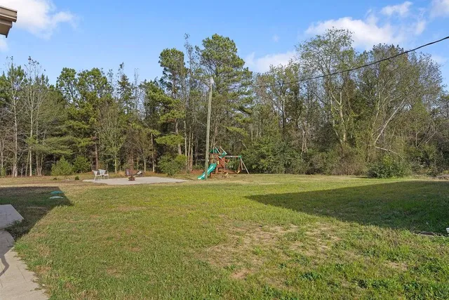 a view of a grassy field with trees in the background