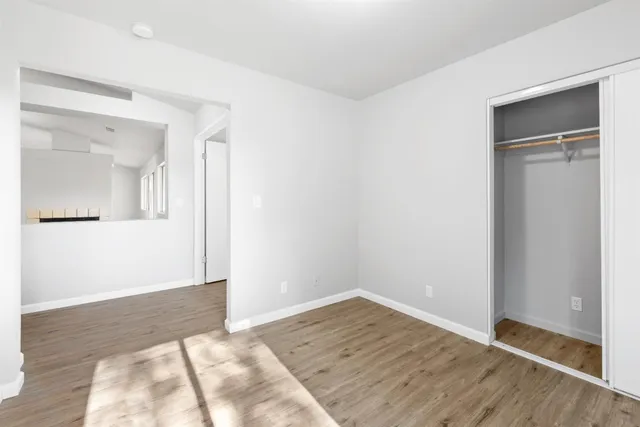 a view of a room with wooden floor and a bathroom