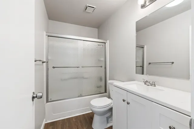 a bathroom with a shower sink vanity mirror and toilet