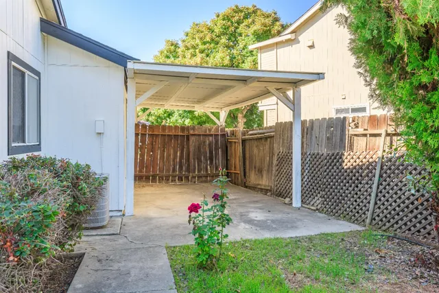 a backyard of a house with plants and wooden fence