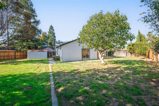 a backyard of a house with table and chairs