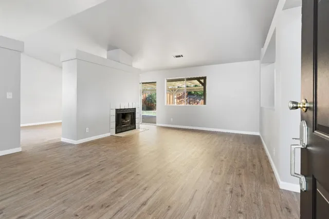 an empty room with windows and fireplace