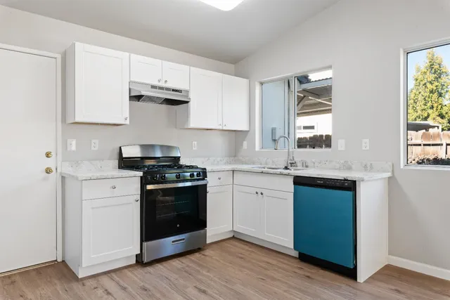 a kitchen with stainless steel appliances granite countertop a stove and a sink