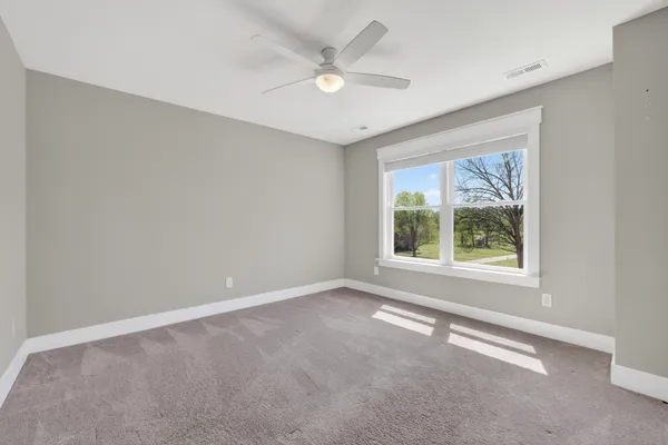 wooden floor in an empty room with a ceiling fan