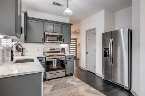 a kitchen with stainless steel appliances granite countertop a refrigerator stove and sink
