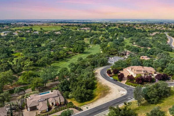 an aerial view of a house with a yard and lake view