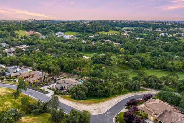 an aerial view of residential houses with outdoor space and trees
