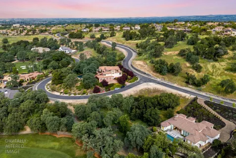 an aerial view of a house with a garden and lake view