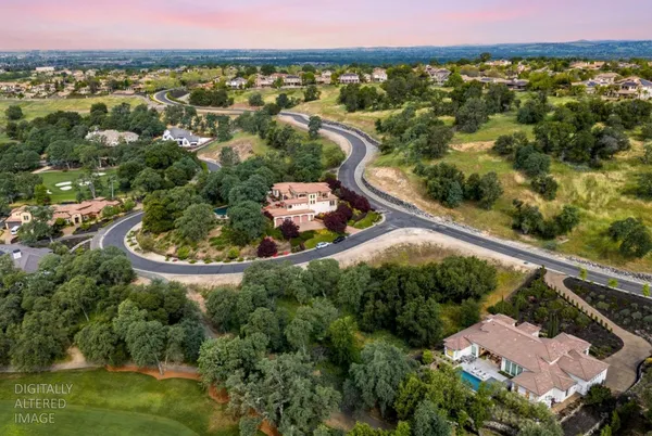 an aerial view of a house with a garden and lake view
