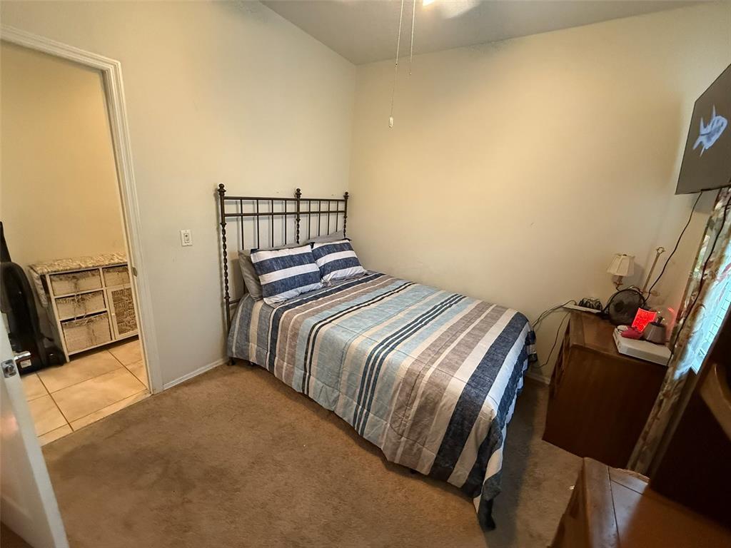 21846 Belgian Court Mount Dora, FL 32757 - Photo 18 of 29 a bedroom with a bed and a flat screen tv
