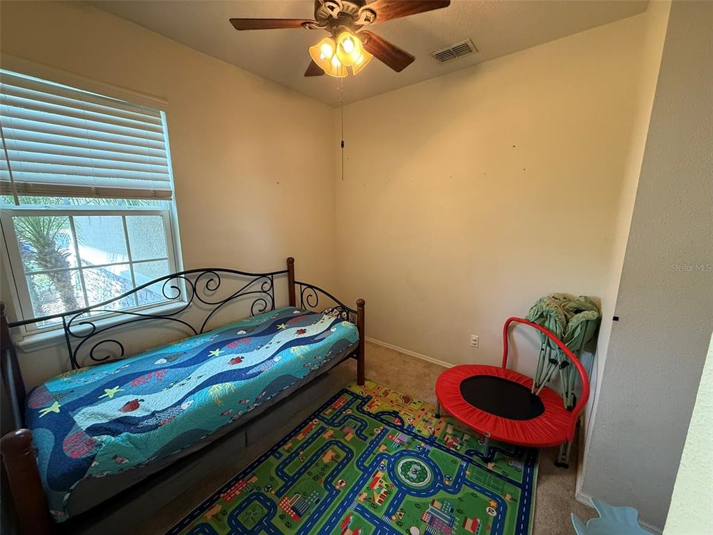 21846 Belgian Court Mount Dora, FL 32757 - Photo 20 of 29 a bedroom with a bed and a chandelier