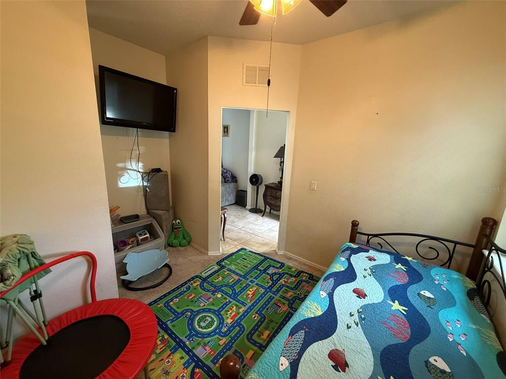 21846 Belgian Court Mount Dora, FL 32757 - Photo 21 of 29 a bedroom with a bed and a tv