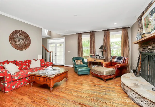 a dining room with furniture wooden floor a rug a potted plant and a chandelier
