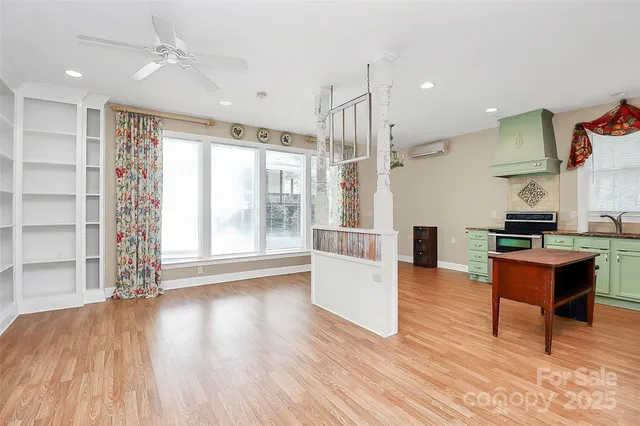 a kitchen with granite countertop a stove cabinets and wooden floor