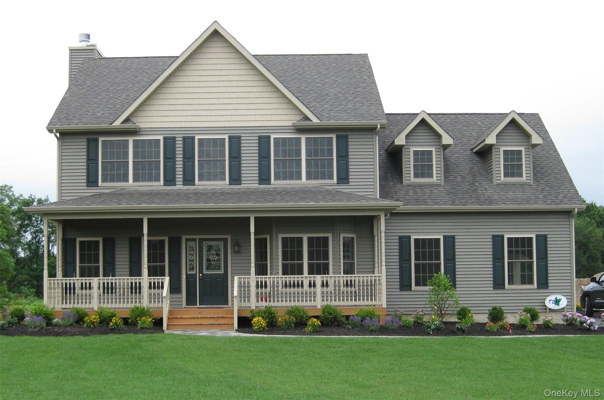 View of front of property featuring a porch, roof with shingles, and a front lawn