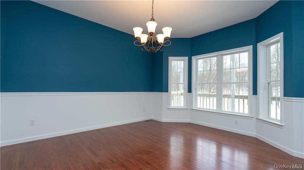 5 Harrier Ridge Drive Wallkill, NY 12589 - Photo 11 of 32 Spare room with a chandelier and dark wood finished floors