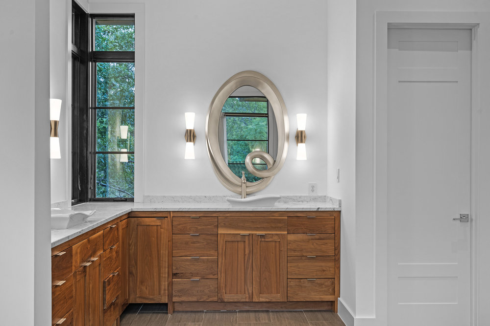 1905 Paisano Road Austin, TX 78746 - Photo 21 of 40 Custom cabinetry and elegant counters complete this naturally illuminated bathroom.