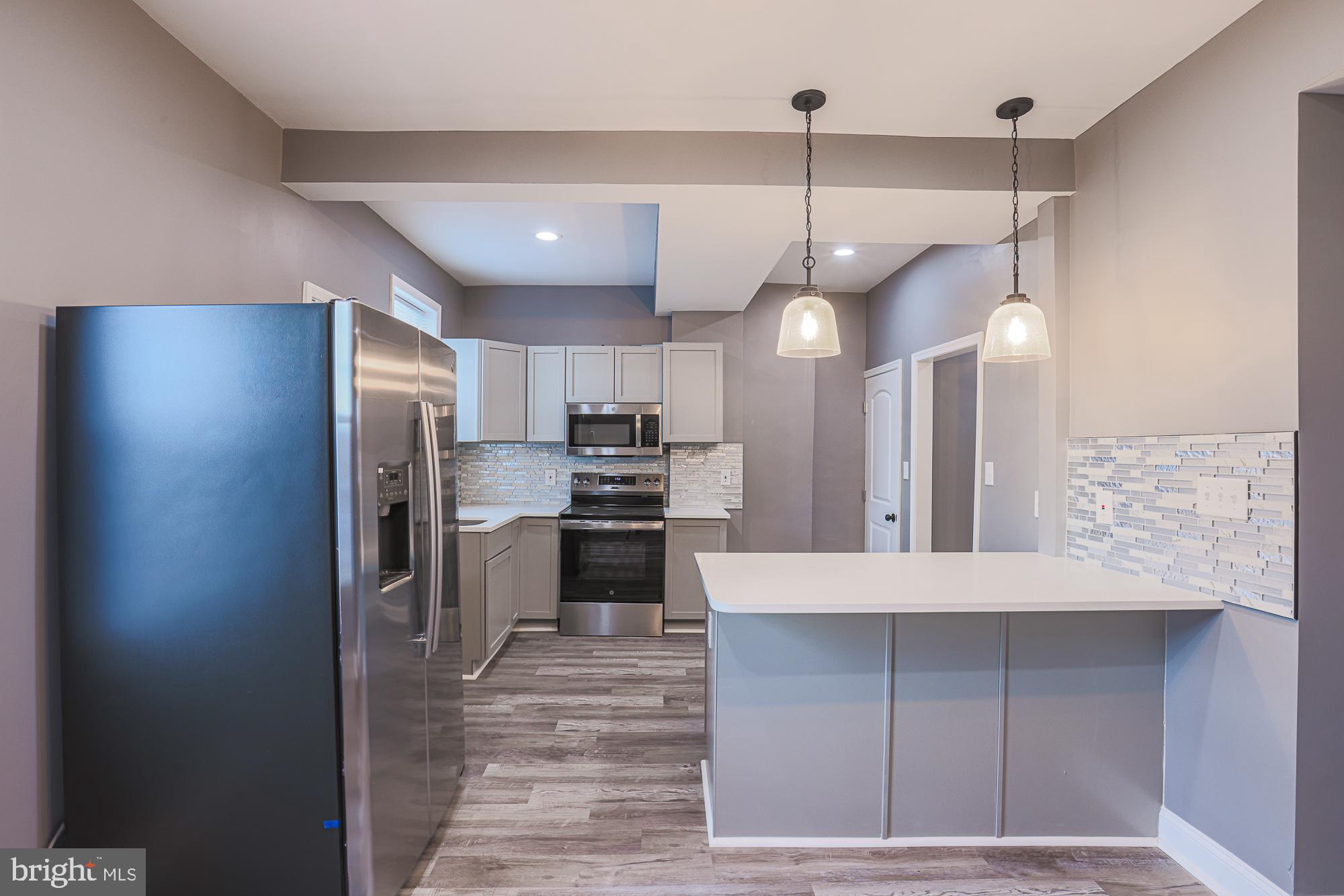 3611 Belair Road Baltimore, MD 21213 - Photo 25 of 60 a kitchen with kitchen island a counter top space a sink and stainless steel appliances