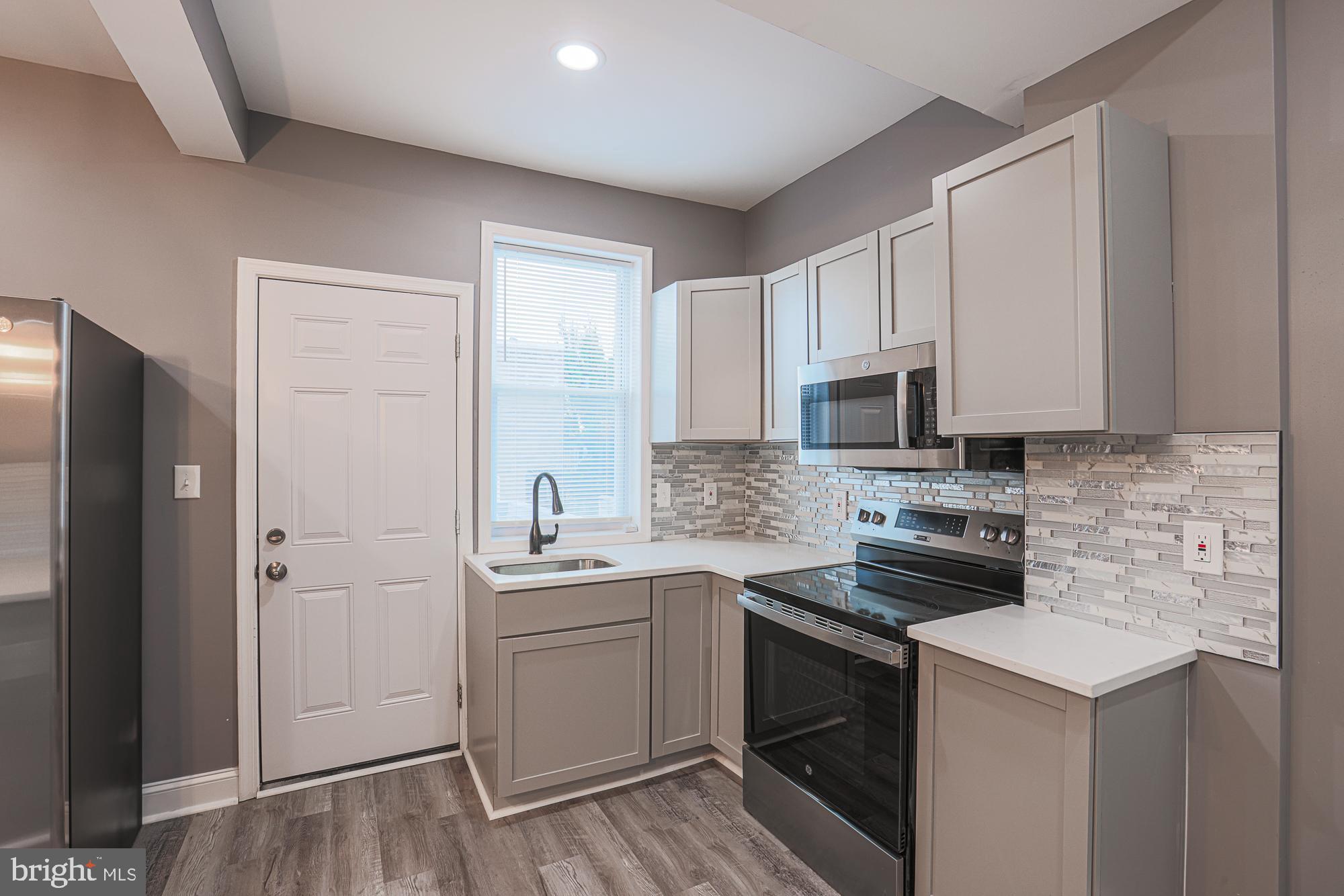 3611 Belair Road Baltimore, MD 21213 - Photo 33 of 60 a kitchen with stainless steel appliances a sink stove and refrigerator