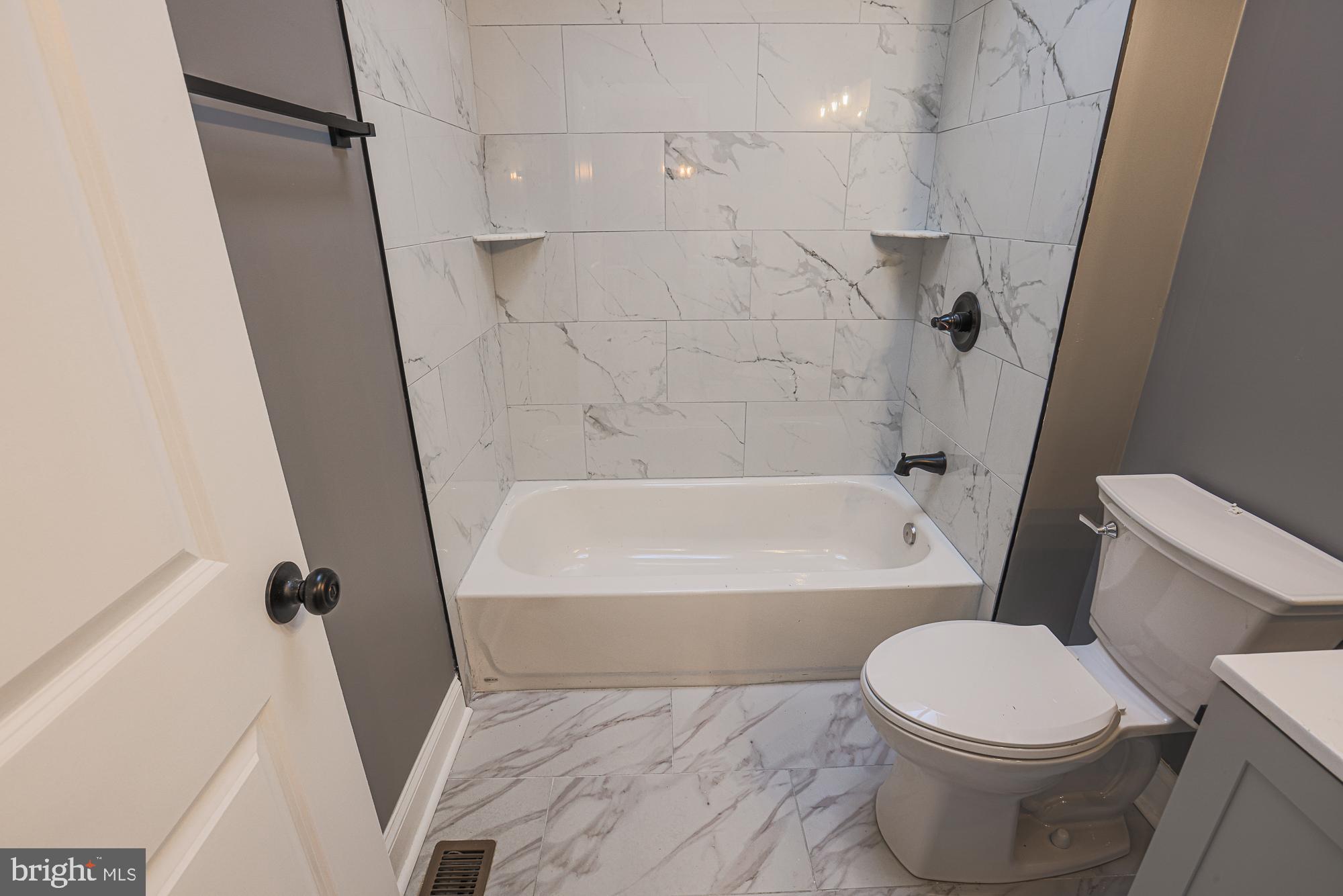 3611 Belair Road Baltimore, MD 21213 - Photo 49 of 60 a white toilet sitting next to a bath tub