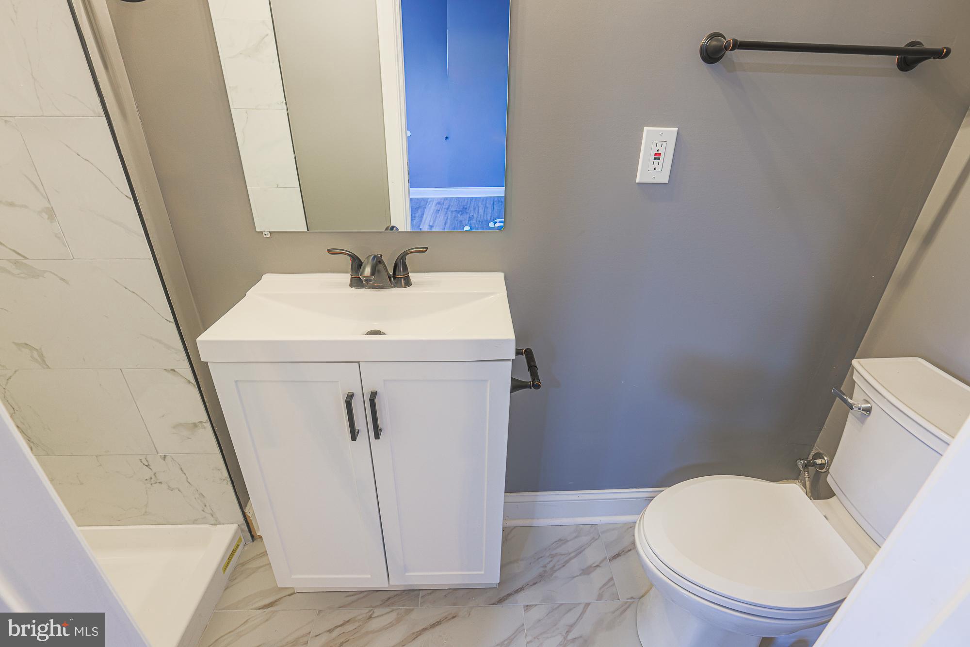3611 Belair Road Baltimore, MD 21213 - Photo 55 of 60 a bathroom with a sink a toilet and a mirror