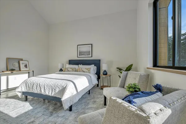 a bedroom with bed couch and window