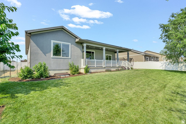 3269 West 650 North Layton, UT 84041 - Photo 34 of 35 Expansive green lawn with a covered patio featuring white railings and columns