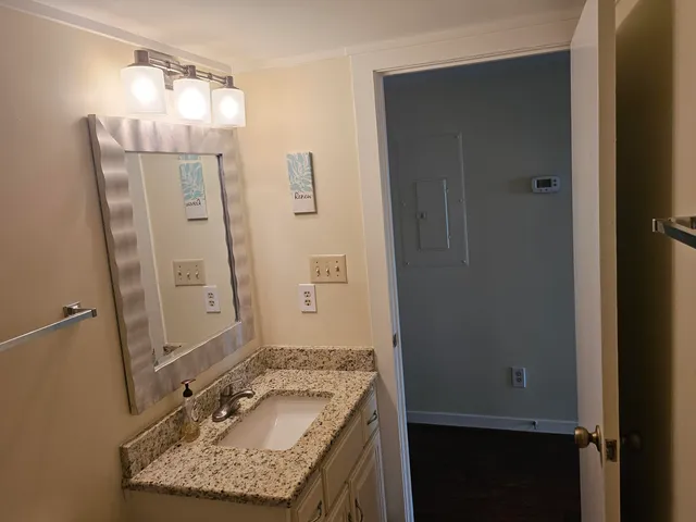 a bathroom with a granite countertop sink and a mirror
