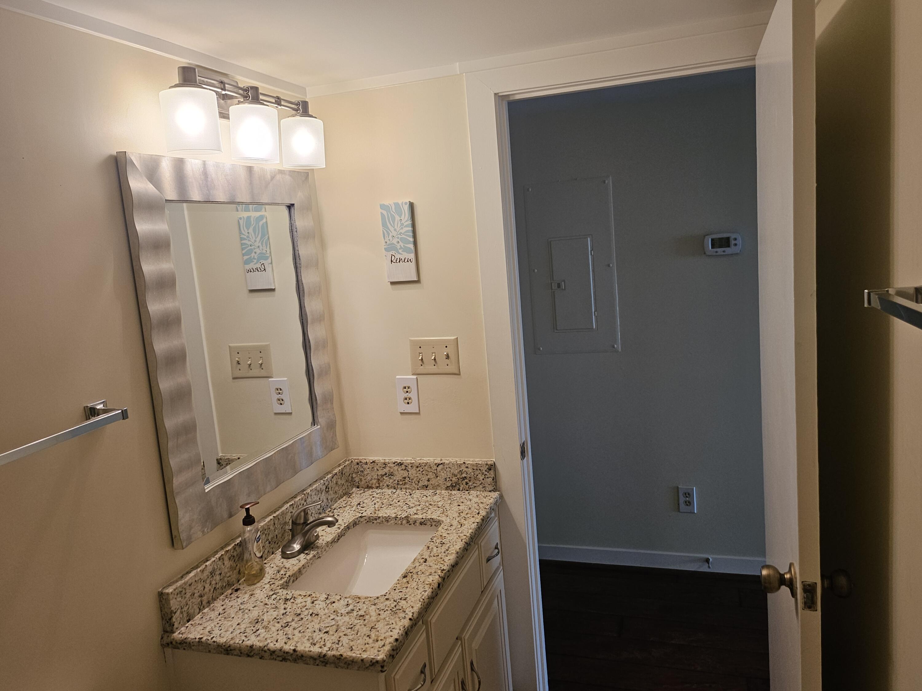 6605 Smith Mountain Road, Unit 101 Penhook, VA 24137 - Photo 13 of 23 a bathroom with a granite countertop sink and a mirror
