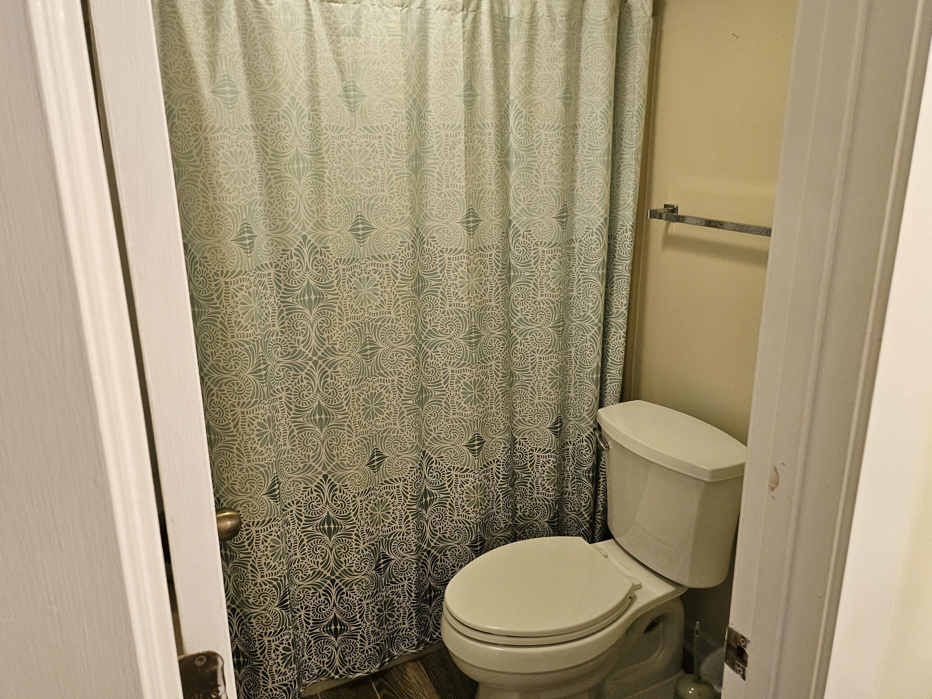 6605 Smith Mountain Road, Unit 101 Penhook, VA 24137 - Photo 15 of 23 a white toilet sitting next to a shower curtain