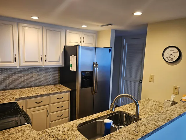 a kitchen with refrigerator a stove a sink and cabinets