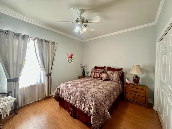 a large bed sitting in a bedroom and table next to a window