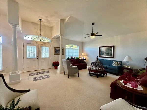 a living room with furniture a chandelier and a window