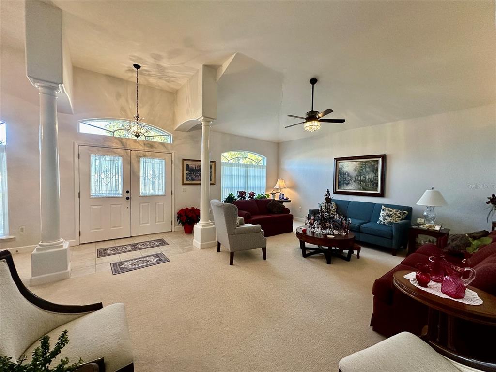357 Ruby Lake Loop Winter Haven, FL 33884 - Photo 2 of 31 a living room with furniture a chandelier and a window