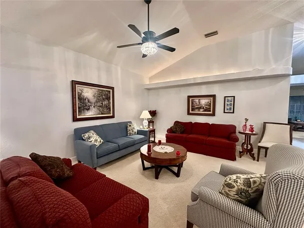 a living room with furniture and a ceiling fan