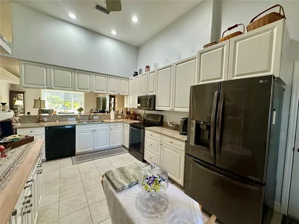 a kitchen with granite countertop a refrigerator and stainless steel appliances