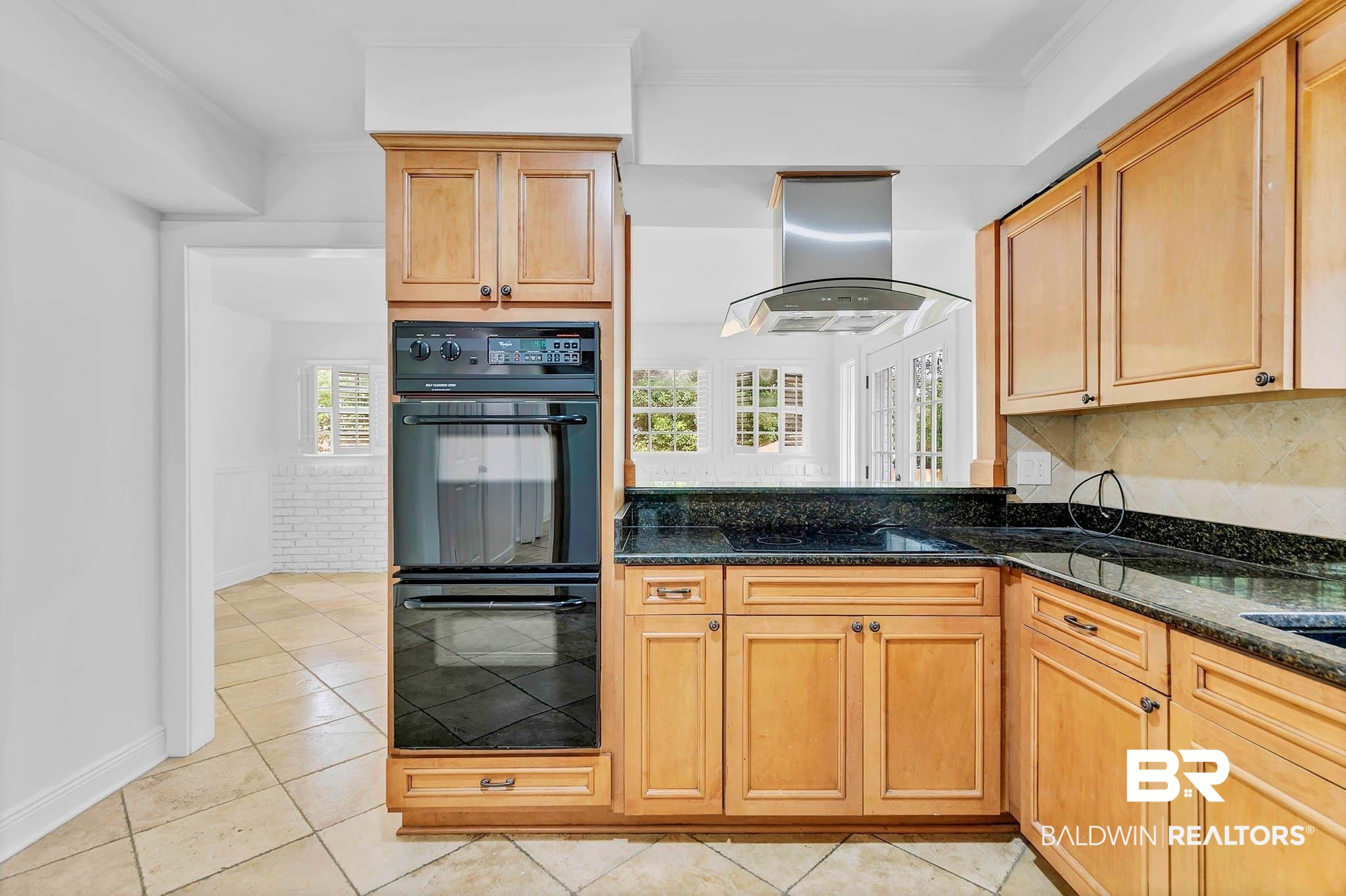 4705 Sherry Court Mobile, AL 36693 - Photo 19 of 100 Kitchen with dark stone counters, light tile patterned floors, island range hood, backsplash, and ornamental molding