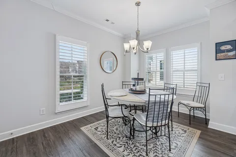 a view of a dining room with furniture a chandelier and wooden floor