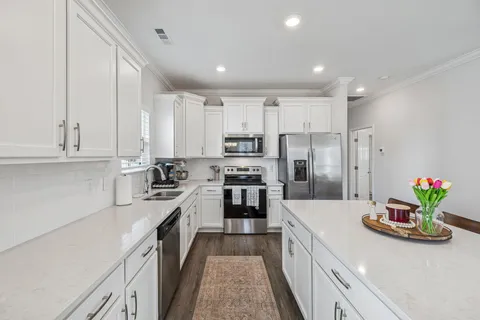 a kitchen with kitchen island granite countertop lots of counter top space and refrigerator