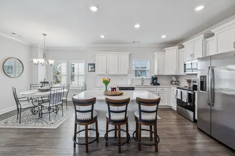 a kitchen with stainless steel appliances kitchen island granite countertop a table and chairs