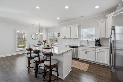a kitchen with a dining table chairs refrigerator and cabinets