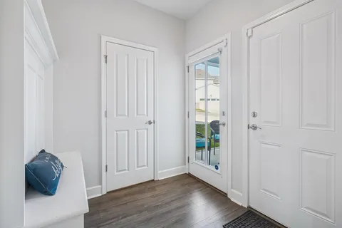 a view of a hallway to rooms and wooden floor
