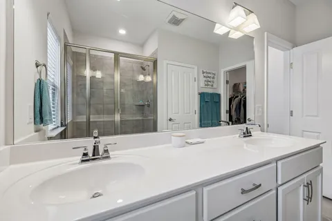 a bathroom with a sink and a mirror with bathtub