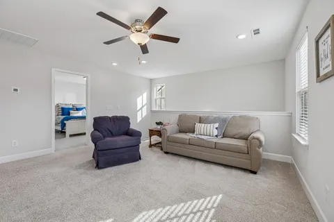 a living room with furniture and a ceiling fan