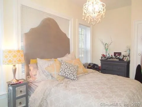 a bedroom with a large bed and a chandelier