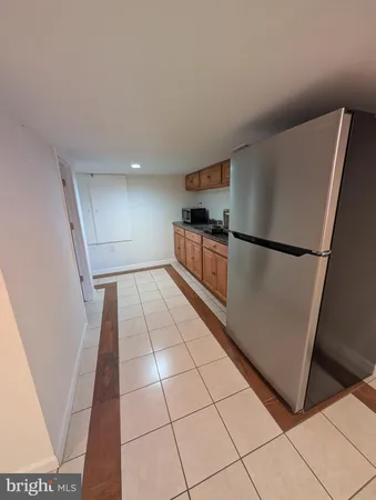 a kitchen with granite countertop a refrigerator and a stove top oven